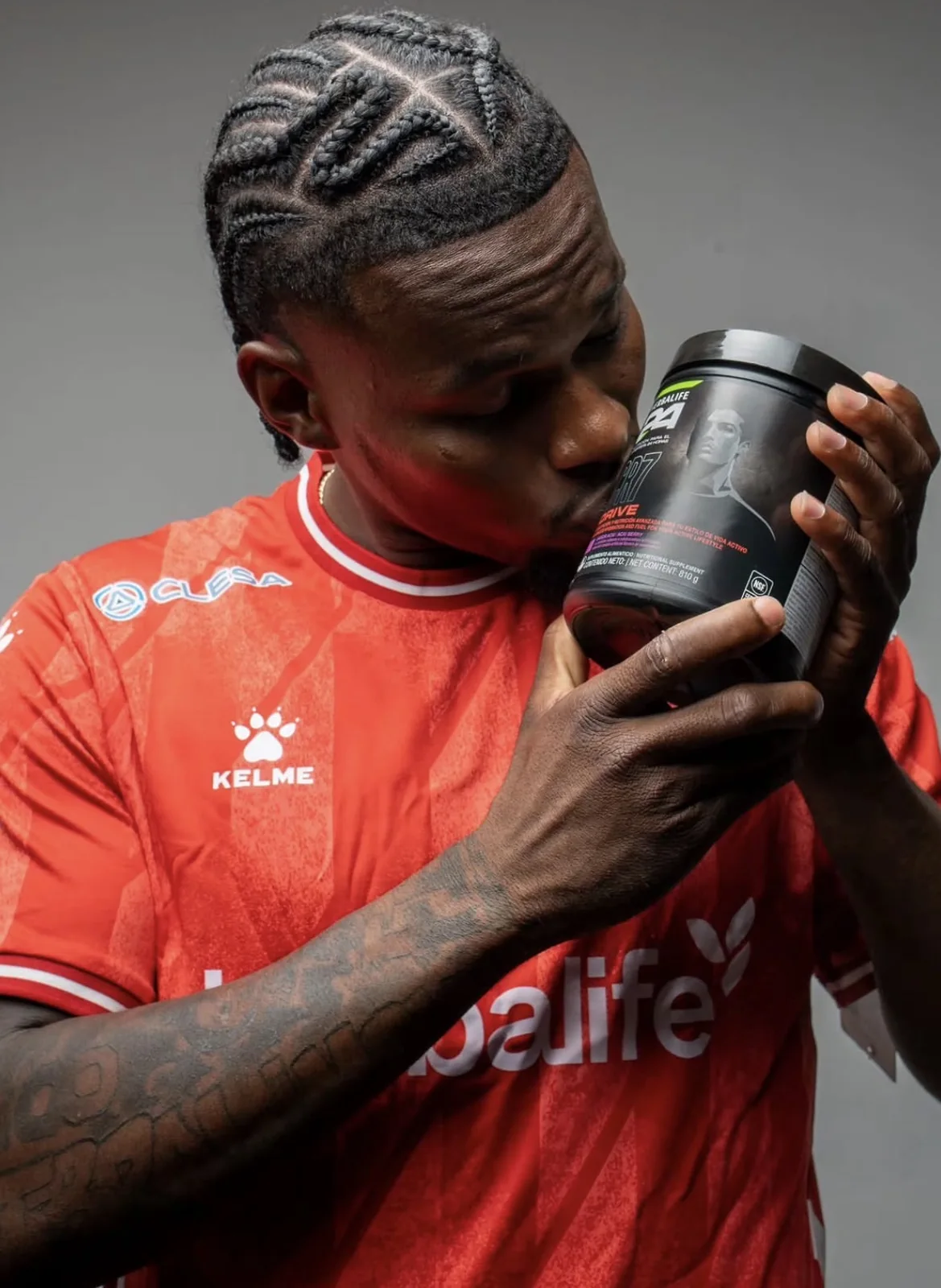 Jugador de camiseta roja besando el producto de su patrocinador, foto de estudio